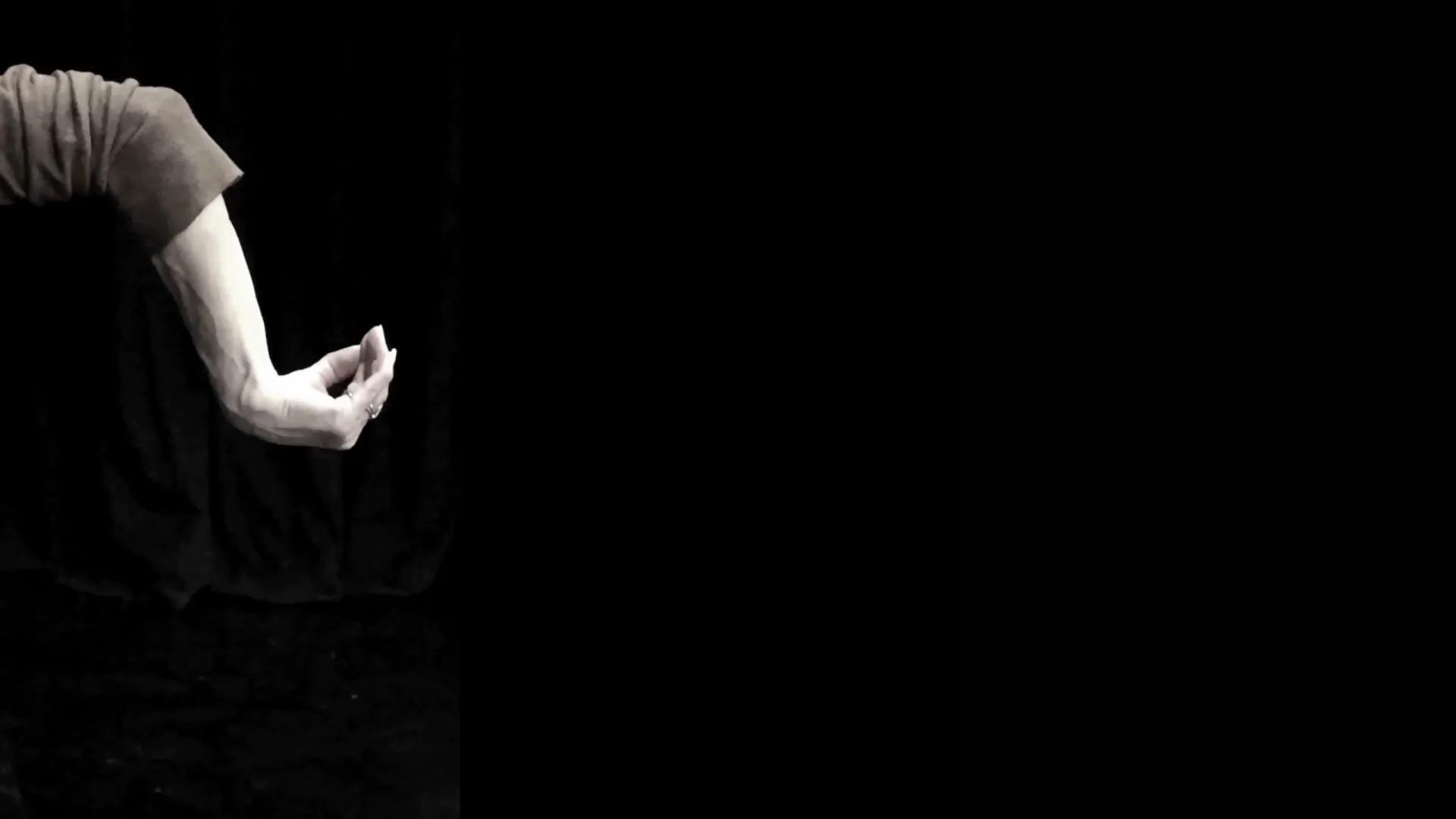 An image of an arm and hand agains a black background. The wrist, thumb and fingers are folding in towards the forearm.