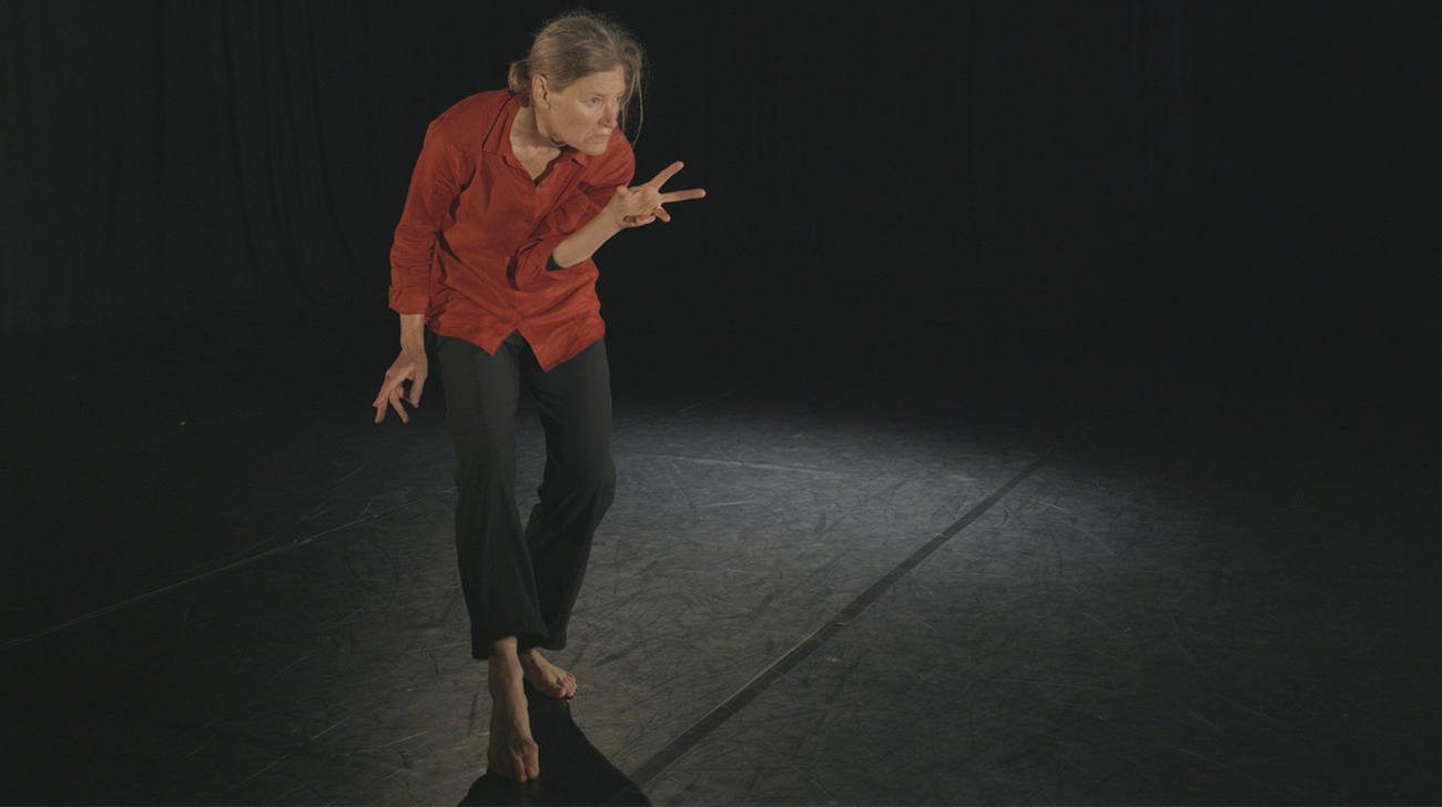 Person dancing with an intense attention, fingers reaching in odd directions, body hunched as if ready to pounce.