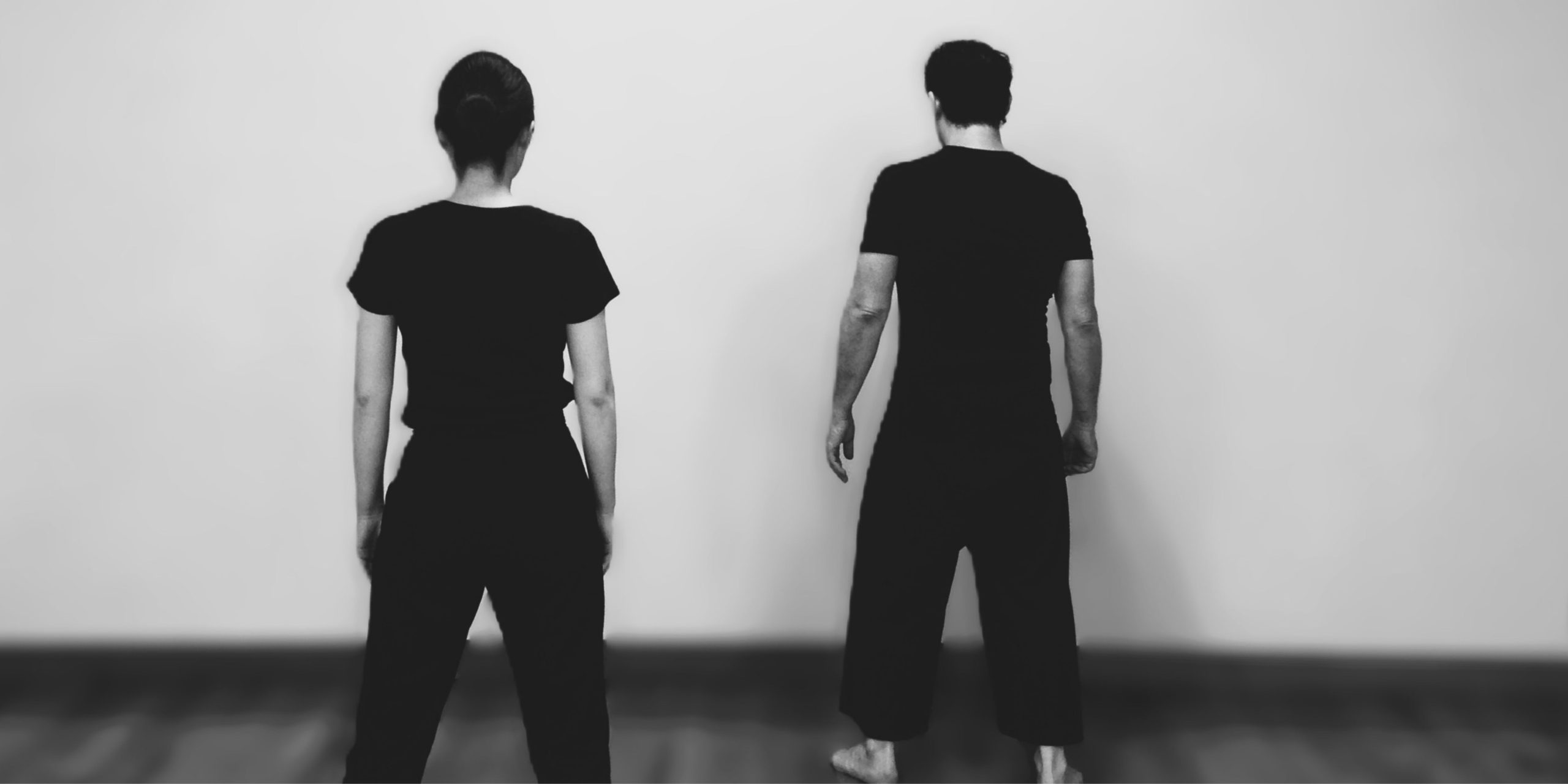 Two people with standing with their backs to the viewer.